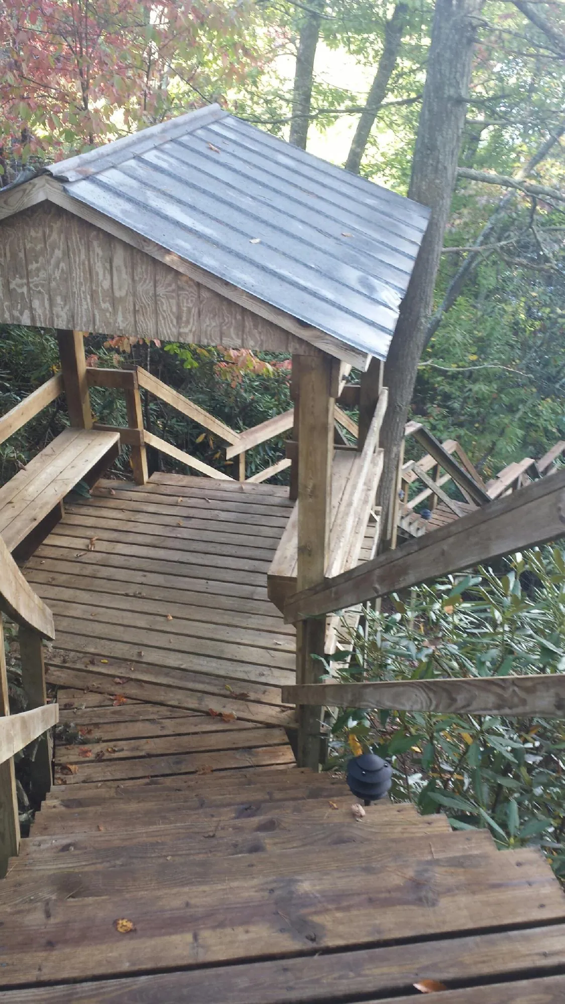 Metal roofed shelter over wooden steps on a wooded walkway — Skylight Repair & Installation work by our crew in Ellington