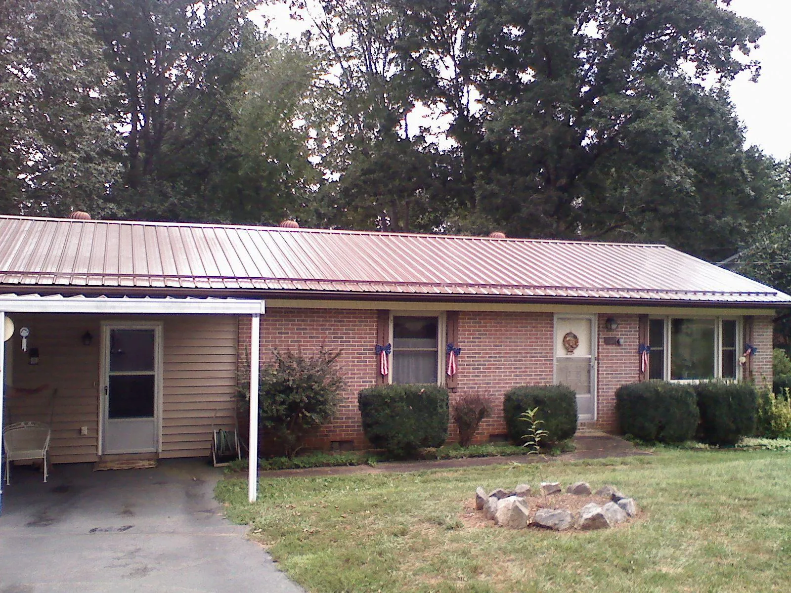 Bronze metal roof and carport on a brick ranch home — Roof Repair work by our crew in Ellington
